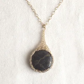 Large round Pyrite pendant necklace, nested in gold wire crochet