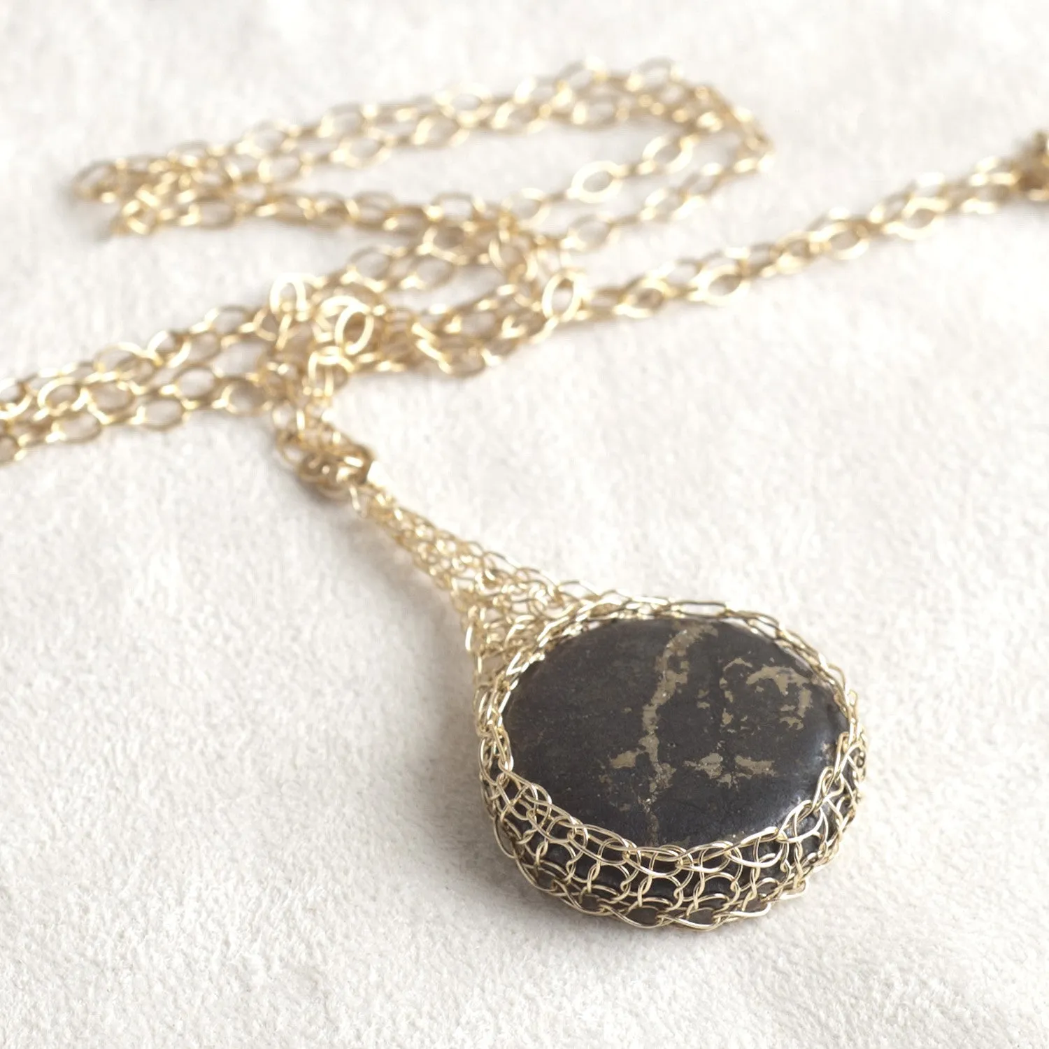 Large round Pyrite pendant necklace, nested in gold wire crochet